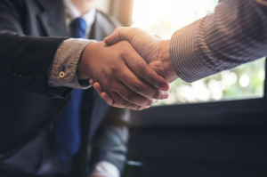 Two business men shaking hands during a meeting to sign agreemen